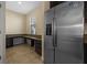 Kitchen with stainless steel refrigerator, built-in desk, tile floor, and natural light from window at 19429 Paddock View Dr, Tampa, FL 33647