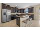 A modern kitchen featuring dark wood cabinets, stainless steel appliances, and a center island with seating at 19429 Paddock View Dr, Tampa, FL 33647
