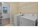 Laundry room featuring washer, dryer, shelving and an adjacent walk-in closet at 19429 Paddock View Dr, Tampa, FL 33647