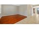 An empty living room featuring hardwood and tile floors, neutral walls, and natural lighting at 19429 Paddock View Dr, Tampa, FL 33647