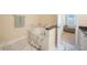 Well-lit bathroom featuring soaking tub, marble accents, and an open doorway to a sitting area at 3410 Sondrio Cir, Tampa, FL 33611