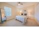 Cozy bedroom features a ceiling fan, large window, and neutral carpeting at 3410 Sondrio Cir, Tampa, FL 33611