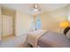 Comfortable bedroom features a ceiling fan, large window, and neutral carpeting at 3410 Sondrio Cir, Tampa, FL 33611