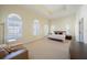 Expansive bedroom featuring tray ceilings, neutral carpet, and many windows at 3410 Sondrio Cir, Tampa, FL 33611