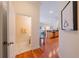 Hallway with hardwood floors leads to a charming powder room and continues to a living space at 3410 Sondrio Cir, Tampa, FL 33611