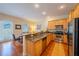 Charming kitchen featuring wood cabinets, granite countertops, stainless appliances, and hardwood floors at 3410 Sondrio Cir, Tampa, FL 33611
