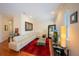 Bright living room featuring a large white couch, red rug, and hardwood flooring at 3410 Sondrio Cir, Tampa, FL 33611