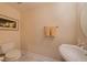 Intimate powder room with a modern toilet and pedestal sink with marble flooring at 3410 Sondrio Cir, Tampa, FL 33611
