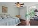 This bedroom has light green walls, hardwood floors, and natural light from a large window at 4810 W San Miguel St, Tampa, FL 33629
