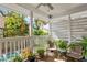 Inviting porch with outdoor seating and a glimpse of the swimming pool beyond the greenery at 4810 W San Miguel St, Tampa, FL 33629