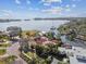 Aerial view of a waterfront home with mature landscaping, a dock, and views of the bay at 4811 Paradise S Way, St Petersburg, FL 33705