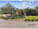 Well-maintained lawn and manicured shrubs in front of home with mature trees providing shade at 4811 Paradise S Way, St Petersburg, FL 33705