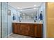 Bathroom with a double vanity, LED mirror, and a glimpse of the glass-enclosed shower at 5701 Mariner St # 606, Tampa, FL 33609