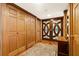 Wooden entryway with ornate double doors, complemented by wooden paneling, a vintage rug, and a side cabinet at 5701 Mariner St # 606, Tampa, FL 33609