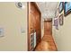 Hallway featuring hardwood floors, wood trim, and multiple framed photos lining the wall at 5701 Mariner St # 606, Tampa, FL 33609
