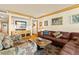 Comfortable living room featuring a leather couch, patterned chair, and entertainment center with a large screen TV at 5701 Mariner St # 606, Tampa, FL 33609