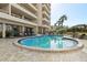 Beautiful building with a round swimming pool surrounded by lounge chairs and palm trees at 5701 Mariner St # 606, Tampa, FL 33609