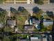 Aerial view of home featuring a pool, lush landscaping, a driveway, and solar panels at 6342 5Th N Ave, St Petersburg, FL 33710