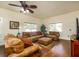 Comfortable living room featuring ample seating, hardwood floors, bright windows, and a ceiling fan at 6342 5Th N Ave, St Petersburg, FL 33710