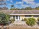 Yellow home with a backyard brick patio surrounded by lush foliage at 1003 De Soto Dr # 2, Dunedin, FL 34698