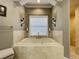 Stylish bathroom featuring a tile-surround bathtub with candle lighting fixtures on the walls at 11158 Warm Wind Way, Weeki Wachee, FL 34613