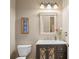 Powder room with decorative mirror, single vanity with dark cabinets, and natural light at 11158 Warm Wind Way, Weeki Wachee, FL 34613