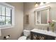Powder room with decorative mirror, single vanity with dark cabinets, and natural light at 11158 Warm Wind Way, Weeki Wachee, FL 34613