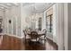 Inviting dining room featuring a round table, elegant chandelier, and natural light from large windows at 11158 Warm Wind Way, Weeki Wachee, FL 34613