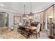 Dining room features travertine floors, a tray ceiling, and pendant lighting over a long wooden table at 11158 Warm Wind Way, Weeki Wachee, FL 34613