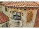 Close-up of a luxury home's architectural detail featuring a balcony, tile roof, and stone accents at 11158 Warm Wind Way, Weeki Wachee, FL 34613