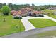Elegant estate featuring lush landscaping, a circular driveway, and a Mediterranean-style home at 11158 Warm Wind Way, Weeki Wachee, FL 34613