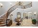Elegant foyer with grand staircase, tile flooring, and decorative mirror at 11158 Warm Wind Way, Weeki Wachee, FL 34613