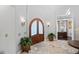 Grand foyer featuring a wooden arched door, tile flooring, and elegant lighting fixtures at 11158 Warm Wind Way, Weeki Wachee, FL 34613