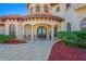 Elegant home entrance with arched doorways, columns, and decorative landscaping at 11158 Warm Wind Way, Weeki Wachee, FL 34613