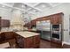Gourmet kitchen featuring stainless steel appliances, granite countertops, and a large center island with custom cabinetry at 11158 Warm Wind Way, Weeki Wachee, FL 34613