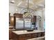 Chef's kitchen boasts a large island, granite countertops, dark wood cabinetry, and stainless steel appliances at 11158 Warm Wind Way, Weeki Wachee, FL 34613