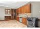 Cherry style cabinetry adorn this kitchenette which also contains mosaic tile, stainless steel appliances, and a washer/dryer unit at 11158 Warm Wind Way, Weeki Wachee, FL 34613