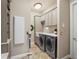 Neutral tone laundry room with overhead lighting, shaker style cabinets, countertop, and a front load washer/dryer at 11158 Warm Wind Way, Weeki Wachee, FL 34613