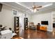 Comfortable living room with hardwood floors, ceiling fan, and relaxing leather chair at 11158 Warm Wind Way, Weeki Wachee, FL 34613
