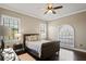 Bedroom with a leather bed, neutral decor, large windows and hardwood floors at 11158 Warm Wind Way, Weeki Wachee, FL 34613