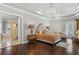 Luxurious main bedroom with a chandelier, hardwood floors, and an ensuite bathroom at 11158 Warm Wind Way, Weeki Wachee, FL 34613