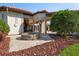 Stone outdoor fireplace with travertine tile and red rock surround, near colonnade and green shrubbery at 11158 Warm Wind Way, Weeki Wachee, FL 34613