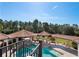 Aerial view of a gorgeous pool with a rock waterfall feature surrounded by lush landscaping and covered sitting areas at 11158 Warm Wind Way, Weeki Wachee, FL 34613