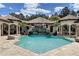 Stunning in-ground pool with a rock waterfall feature, fountains and covered outdoor sitting areas at 11158 Warm Wind Way, Weeki Wachee, FL 34613