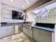 An outdoor kitchen with built-in grill, sink, and TV at 2385 Arboretum Dr, Palm Harbor, FL 34683