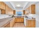 Functional kitchen with light wood cabinets, laminate countertops, and wood-style flooring at 2709 57Th S St, Gulfport, FL 33707
