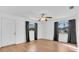 Spacious, sunlit living room with wood floors, ceiling fan, and windows with dark curtains at 2709 57Th S St, Gulfport, FL 33707