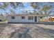 Charming exterior of renovated home featuring white painted brick, a covered carport, and dark trim at 7605 35Th S Ave, Tampa, FL 33619