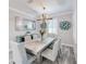 Dining room with modern chandelier, seating for six, and views of the decorative mirror and accent wall at 817 Wilkie St, Dunedin, FL 34698
