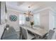 Dining room featuring modern chandelier, table seating for six, and natural light from shuttered windows at 817 Wilkie St, Dunedin, FL 34698